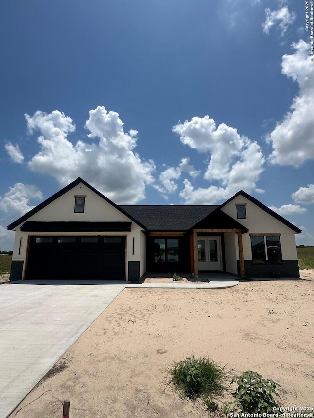129 Merion Ln, Vernia, TX 78121 - view of front of property with french doors, an attached garage, stucco siding, and driveway