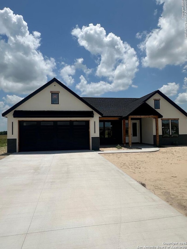 129 Merion Ln, Vernia, TX 78121 - view of front of home featuring concrete driveway, stucco siding, and an attached garage