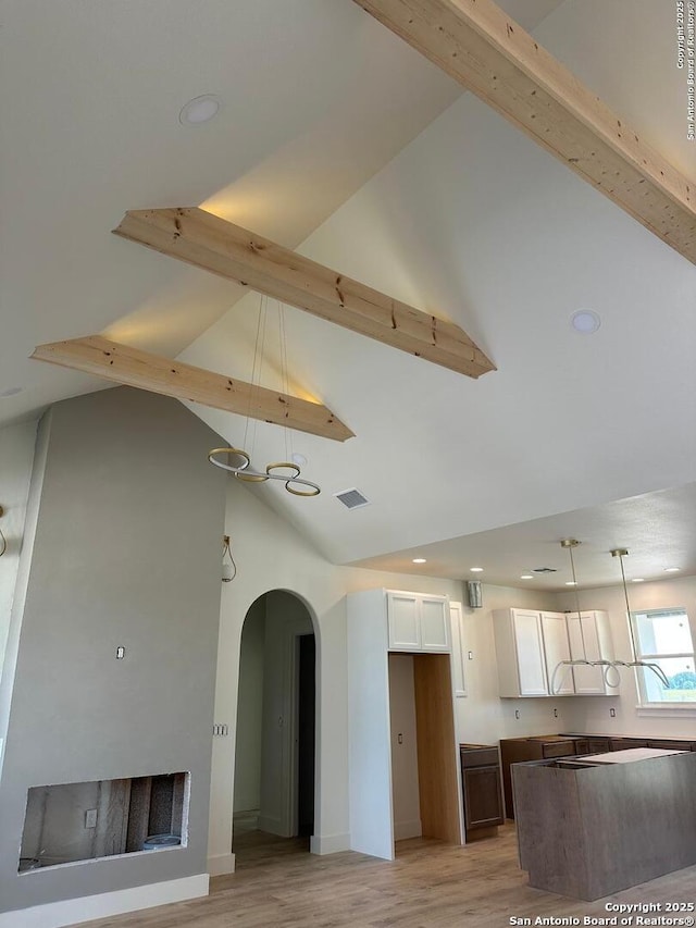 129 Merion Ln, Vernia, TX 78121 - kitchen with arched walkways, white cabinetry, light wood-style flooring, high vaulted ceiling, and beamed ceiling