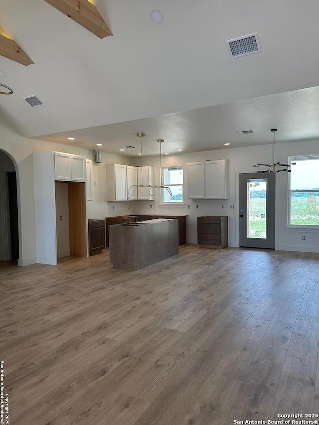 129 Merion Ln, Vernia, TX 78121 - unfurnished living room with healthy amount of natural light, light wood-style flooring, arched walkways, recessed lighting, and a chandelier