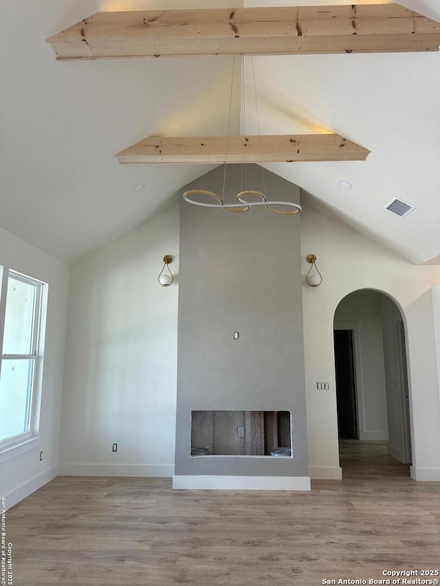 129 Merion Ln, Vernia, TX 78121 - unfurnished living room with high vaulted ceiling, wood finished floors, a fireplace, a chandelier, and arched walkways