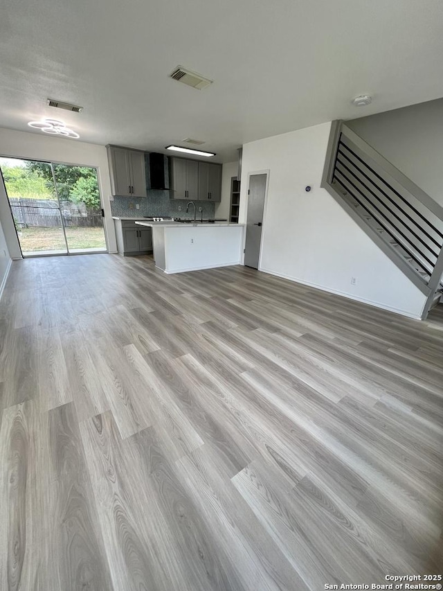 7947 Ruby Mdws, San Antonio, TX 78251 - unfurnished living room with light wood-style floors and stairs