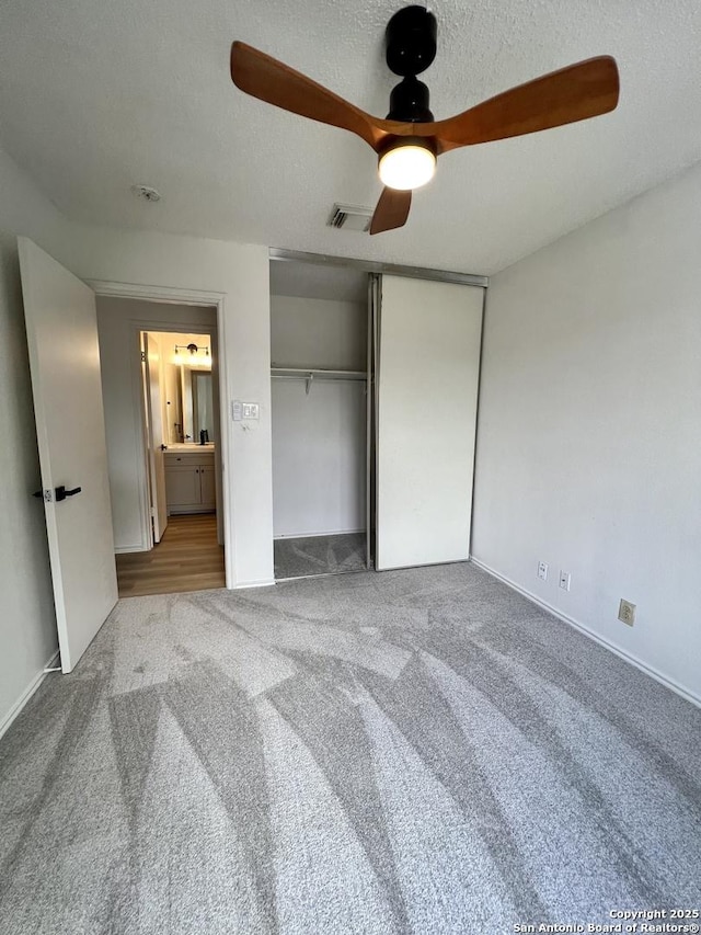 7947 Ruby Mdws, San Antonio, TX 78251 - unfurnished bedroom featuring carpet, a textured ceiling, a ceiling fan, and a closet