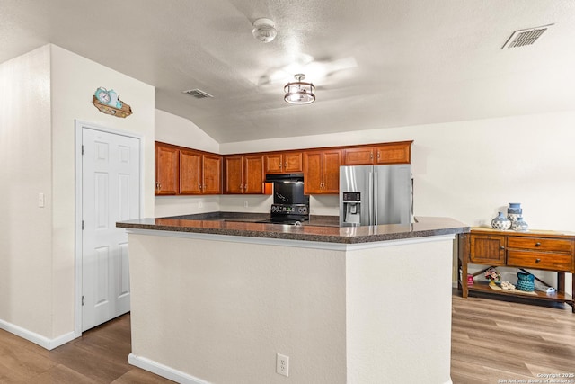 9235 Everton, San Antonio, TX 78245 - kitchen with stainless steel fridge, lofted ceiling, black electric range oven, wood finished floors, and dark countertops