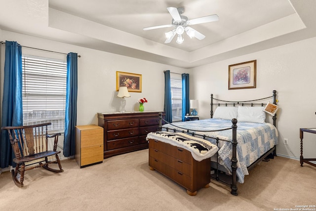9235 Everton, San Antonio, TX 78245 - bedroom with light carpet, a tray ceiling, and a ceiling fan