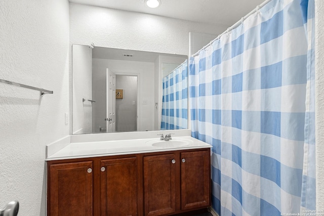 9235 Everton, San Antonio, TX 78245 - bathroom featuring a textured wall, vanity, and a shower with shower curtain