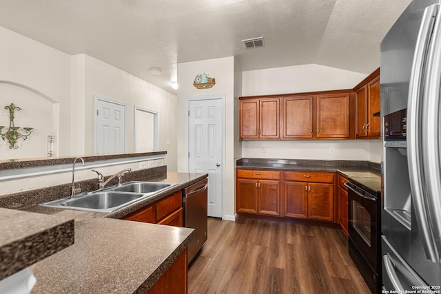 9235 Everton, San Antonio, TX 78245 - kitchen with appliances with stainless steel finishes, dark wood-style flooring, lofted ceiling, dark countertops, and brown cabinets