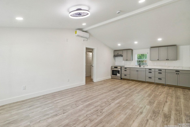 937 Anderson, Seguin, TX 78155 - kitchen with gray cabinets, stainless steel range with electric stovetop, an AC wall unit, light wood-style flooring, and light countertops
