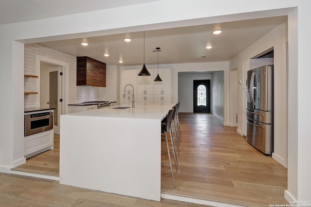 5738 Brenda Ln, San Antonio, TX 78240 - kitchen with appliances with stainless steel finishes, light wood-style flooring, decorative backsplash, white cabinets, and recessed lighting