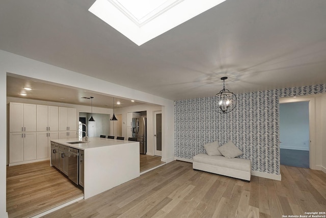 5738 Brenda Ln, San Antonio, TX 78240 - kitchen with appliances with stainless steel finishes, open floor plan, a chandelier, light wood-style floors, and recessed lighting