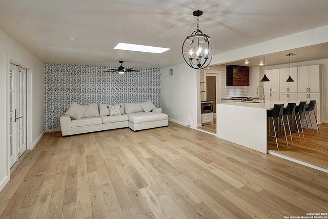 5738 Brenda Ln, San Antonio, TX 78240 - living room with light wood-style flooring, a skylight, a chandelier, and a ceiling fan