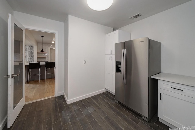 5738 Brenda Ln, San Antonio, TX 78240 - kitchen with stainless steel fridge with ice dispenser, white cabinets, dark wood-style floors, and light countertops