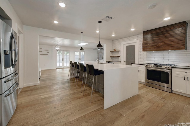 5738 Brenda Ln, San Antonio, TX 78240 - kitchen featuring stainless steel appliances, range hood, light wood-style flooring, a kitchen bar, and recessed lighting