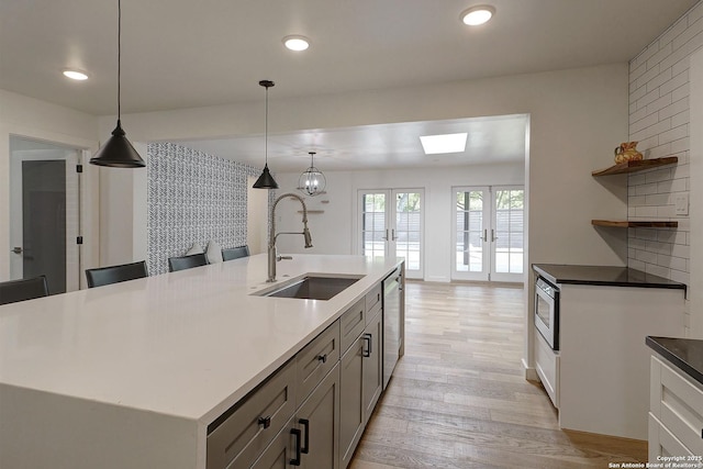 5738 Brenda Ln, San Antonio, TX 78240 - kitchen featuring dishwasher, light wood-type flooring, french doors, open shelves, and pendant lighting