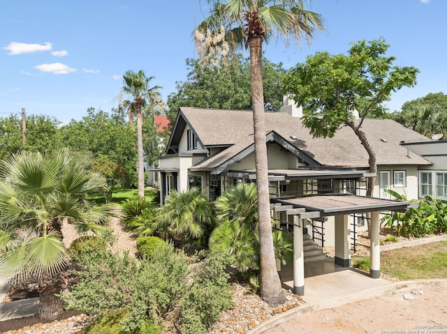 133 E Mistletoe Ave, San Antonio, TX 78212 - view of side of property with stucco siding, a shingled roof, stairs, and a chimney
