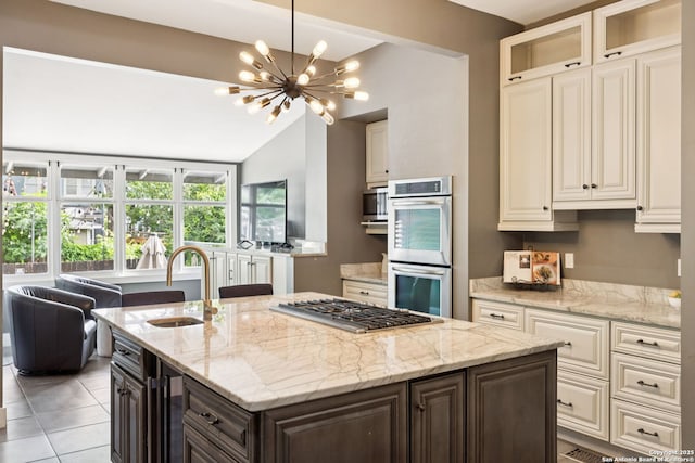 133 E Mistletoe Ave, San Antonio, TX 78212 - kitchen featuring appliances with stainless steel finishes, a chandelier, a kitchen island with sink, lofted ceiling, and light stone countertops