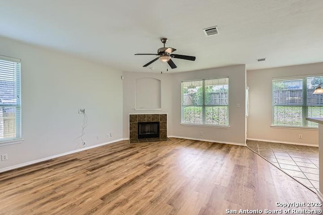2727 Encino Riv, San Antonio, TX 78259 - unfurnished living room with wood finished floors, ceiling fan, and a tiled fireplace
