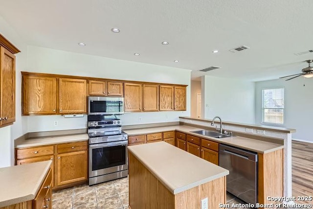 2727 Encino Riv, San Antonio, TX 78259 - kitchen with appliances with stainless steel finishes, a peninsula, a center island, light countertops, and recessed lighting