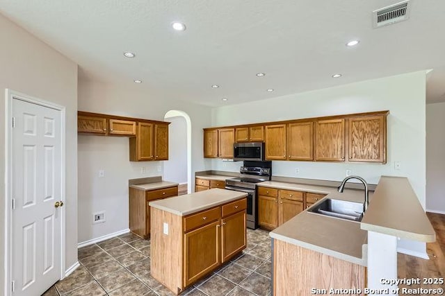 2727 Encino Riv, San Antonio, TX 78259 - kitchen with appliances with stainless steel finishes, brown cabinets, a kitchen island, a peninsula, and recessed lighting