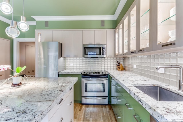 117 Saint Dennis Unit 117, San Antonio, TX 78209 - kitchen featuring stainless steel appliances, crown molding, light wood-type flooring, backsplash, and light stone counters