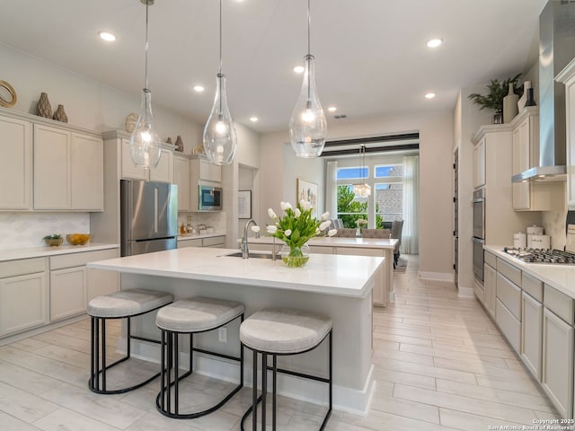 25022 Dulzura, San Antonio, TX 78261 - kitchen featuring stainless steel appliances, an island with sink, wall chimney range hood, light countertops, and recessed lighting