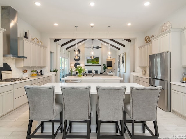 25022 Dulzura, San Antonio, TX 78261 - kitchen featuring stainless steel appliances, wall chimney exhaust hood, a kitchen island with sink, backsplash, and light countertops