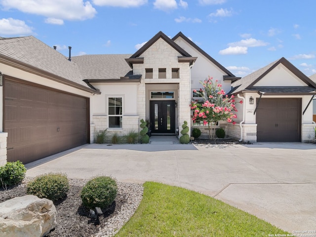 25022 Dulzura, San Antonio, TX 78261 - french country home featuring driveway, stone siding, a garage, french doors, and a shingled roof