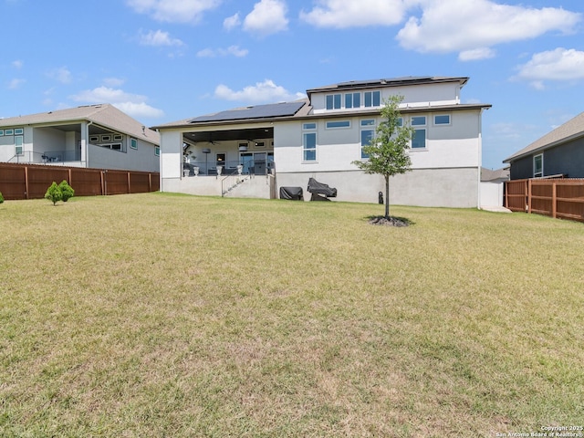 25022 Dulzura, San Antonio, TX 78261 - back of house featuring roof mounted solar panels, a fenced backyard, and stucco siding