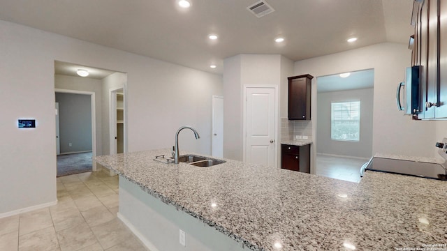 2076 Meadow Pipit, New Braunfels, TX 78130 - kitchen featuring stainless steel microwave, stove, light stone countertops, dark brown cabinets, and recessed lighting