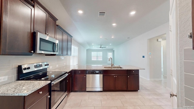 2076 Meadow Pipit, New Braunfels, TX 78130 - kitchen featuring appliances with stainless steel finishes, a peninsula, light tile patterned floors, recessed lighting, and backsplash