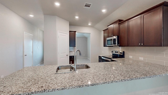 2076 Meadow Pipit, New Braunfels, TX 78130 - kitchen featuring appliances with stainless steel finishes, backsplash, light stone countertops, recessed lighting, and dark brown cabinets