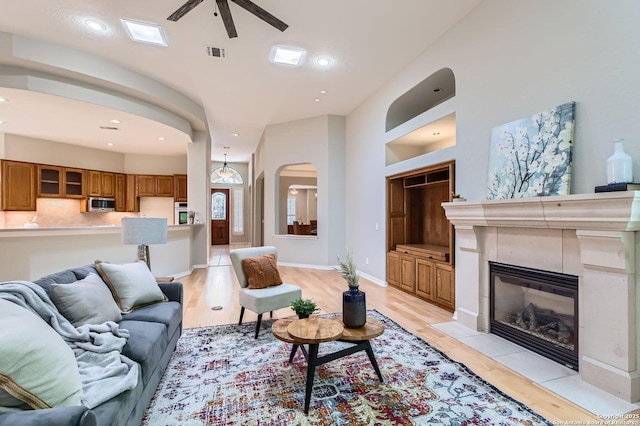 34 Roseheart, San Antonio, TX 78259 - living room with arched walkways, ceiling fan, light wood finished floors, a tiled fireplace, and recessed lighting