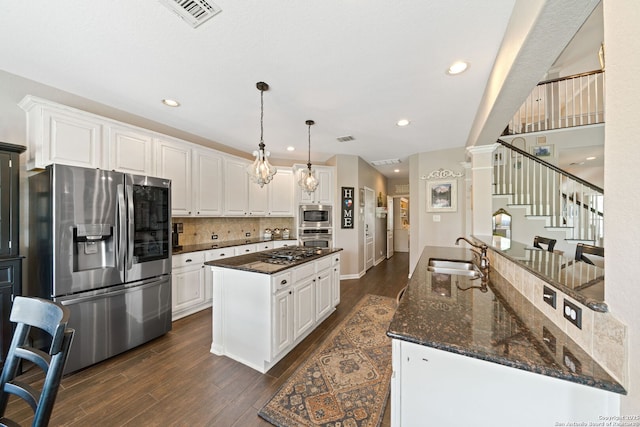 3118 Limestone, San Antonio, TX 78253 - kitchen featuring stainless steel appliances, dark wood-style floors, white cabinets, dark stone countertops, and recessed lighting