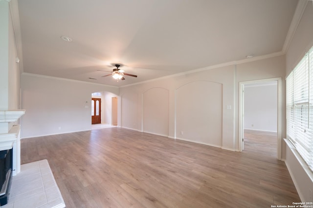 16914 Redhorse Pass, San Antonio, TX 78247 - unfurnished living room featuring arched walkways, a fireplace, ceiling fan, light wood-type flooring, and ornamental molding