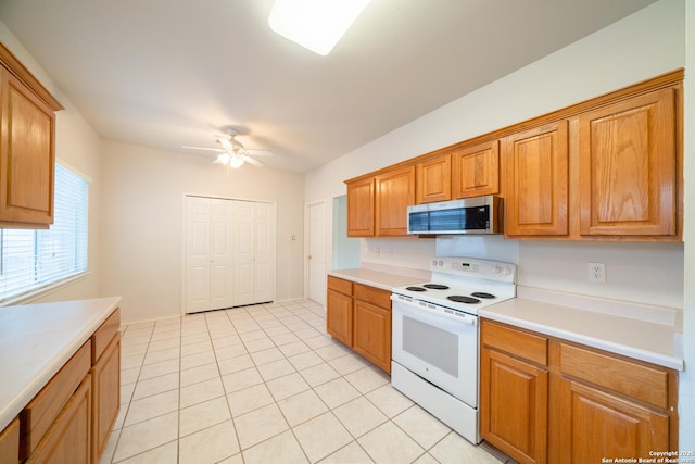 16914 Redhorse Pass, San Antonio, TX 78247 - kitchen with stainless steel microwave, white range with electric cooktop, light tile patterned flooring, light countertops, and a ceiling fan