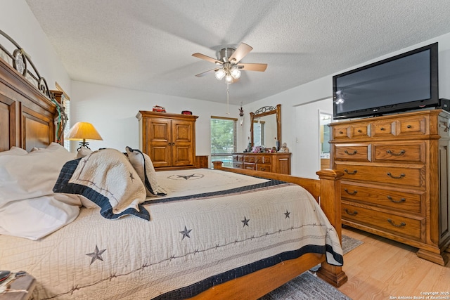 33171 Blanco Rd, Bulverde, TX 78163 - bedroom with light wood-style flooring, a textured ceiling, and ceiling fan