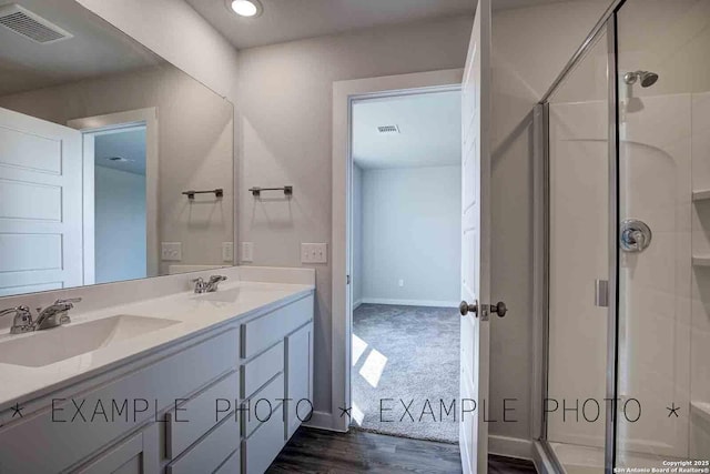 9974 Forestier Grn, San Antonio, TX 78221 - bathroom with a shower stall, double vanity, wood finished floors, and recessed lighting
