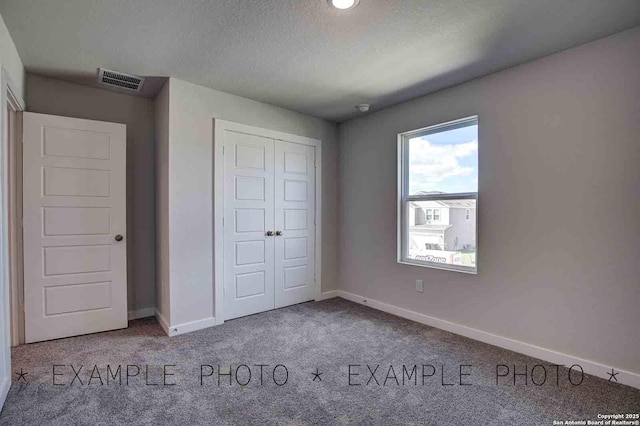 9974 Forestier Grn, San Antonio, TX 78221 - unfurnished bedroom with carpet floors, a closet, and a textured ceiling