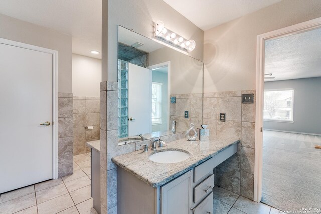 3316 Fresno, Schertz, TX 78154 - bathroom featuring tile walls, tile patterned flooring, vanity, and a wainscoted wall