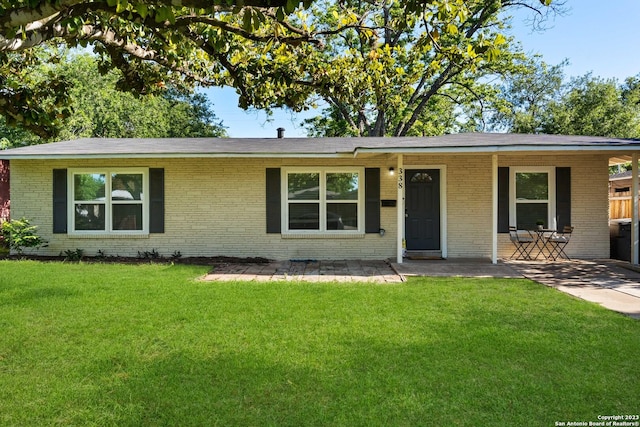 338 Tomrob Dr, San Antonio, TX 78220 - ranch-style house with brick siding, a front yard, and a patio