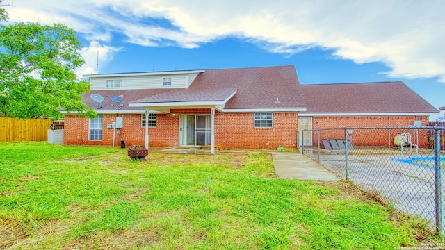 103 Weese, Pleasanton, TX 78064 - rear view of house with brick siding, a fenced backyard, a fire pit, and a gate
