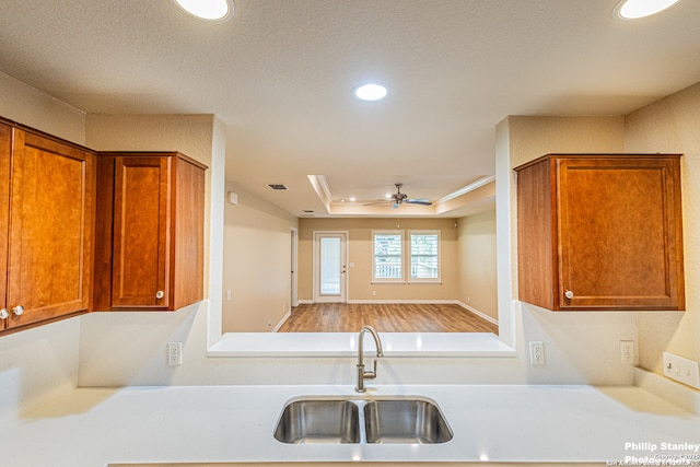 5038 Sandhill Crane, San Antonio, TX 78253 - kitchen featuring light countertops, recessed lighting, brown cabinetry, ceiling fan, and a tray ceiling