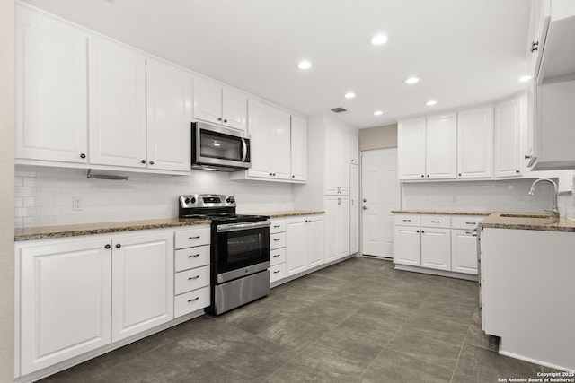 1101 Antler, Schertz, TX 78154 - kitchen featuring appliances with stainless steel finishes, white cabinets, stone counters, tasteful backsplash, and recessed lighting