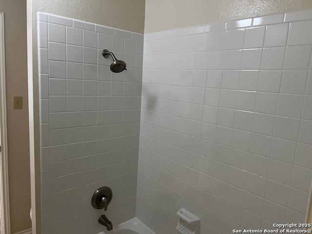 9351 Dover Rdg, San Antonio, TX 78250 - bathroom view of a textured wall and shower / bath combination