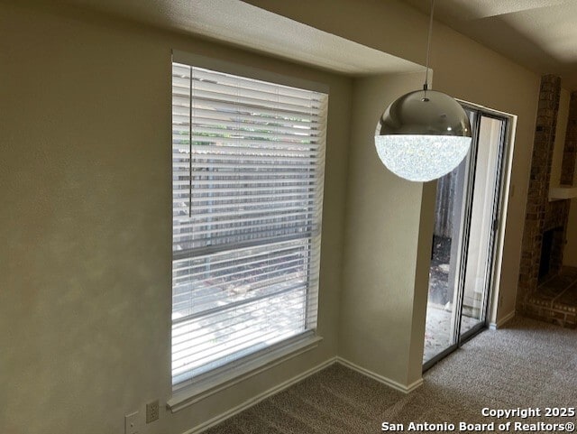 9351 Dover Rdg, San Antonio, TX 78250 - unfurnished dining area with carpet, plenty of natural light, and a brick fireplace