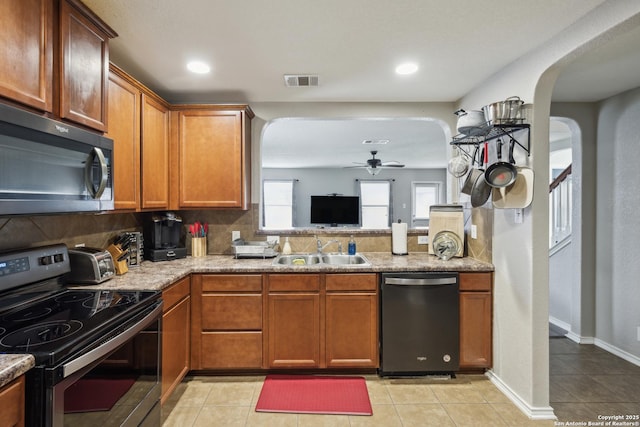 1826 Strawhouse, San Antonio, TX 78245 - kitchen with appliances with stainless steel finishes, ceiling fan, arched walkways, tasteful backsplash, and recessed lighting
