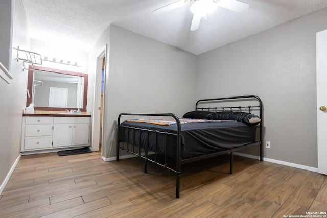 309 Meandering Way, Del Rio, TX 78840 - bedroom with wood finished floors, a textured ceiling, ceiling fan, and ensuite bathroom