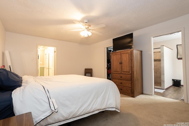 309 Meandering Way, Del Rio, TX 78840 - bedroom with connected bathroom, a textured ceiling, a spacious closet, light carpet, and ceiling fan