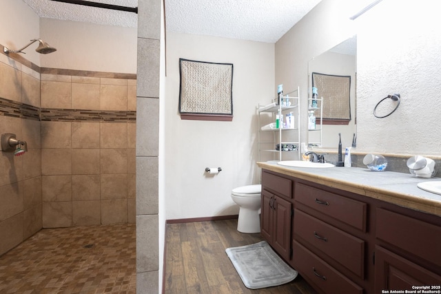 309 Meandering Way, Del Rio, TX 78840 - bathroom featuring walk in shower, double vanity, wood finished floors, and a textured ceiling
