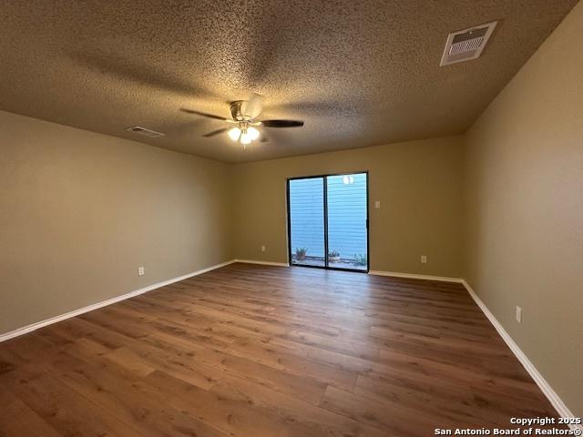16454 Blanco Ky, San Antonio, TX 78247 - empty room featuring dark wood-style floors, ceiling fan, and a textured ceiling